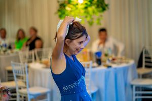 Guest in blue embellished dress dancing at elegant wedding reception.