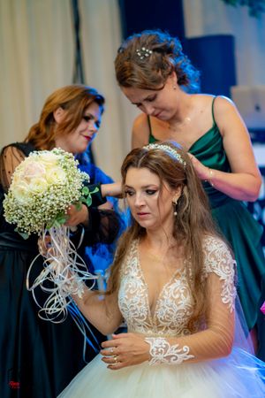 Wedding party gathered around with baby's breath bouquet and formal attire.