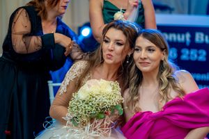 Wedding celebration with attendees in formal attire including bright pink and elegant dresses.