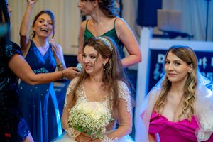 Wedding reception guests dance and celebrate on a blue-lit dance floor at an indoor venue.