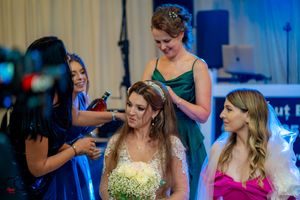 Wedding reception scene with bride and guests in formal attire during celebrations.