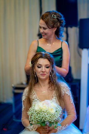 Candid moment of a bride wearing a sheer-sleeved wedding gown with baby's breath flowers.