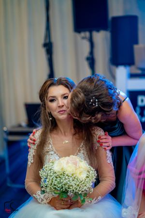 Wedding scene showing a bride in an elegant dress with delicate lace details and floral accents.