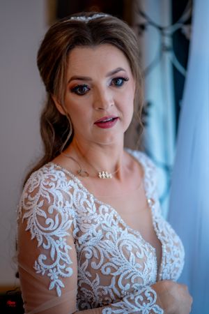 Detailed view of a wedding gown featuring ornate white lace patterns on mesh.
