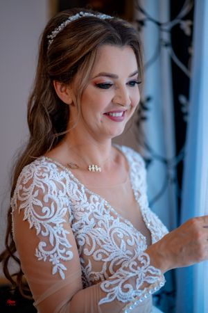 Close-up portrait showing intricate white lace details of a wedding dress with sheer illusion neckline.