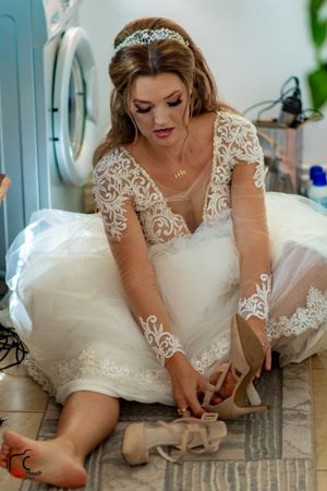 Beautiful bridal preparation sequence showing detailed lace bodice and flowing white dress.