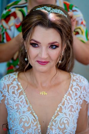 Candid bridal portrait featuring white lace dress, tiara and professional makeup.
