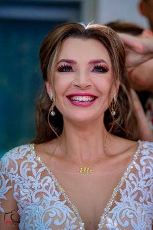 Bridal beauty shot featuring dramatic eye makeup and delicate white lace neckline.