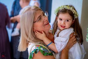 A joyful moment shared between a woman in floral print and a little girl wearing a flower crown.