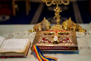 Close-up of ceremonial crowns and candles on an altar with traditional Orthodox wedding items.