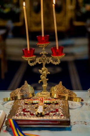 Ornate gold candelabra with red candle holders and decorative details on white tablecloth.