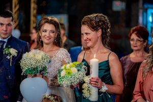Wedding party members pose with bouquets and balloons during the ceremony.