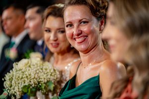 Wedding party members share joyful moments during indoor reception celebration.