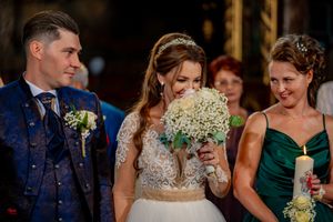 Wedding celebration with attendees in formal attire gathered in an elegant indoor venue.