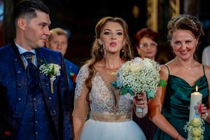 Wedding celebration scene with attendees in formal wear and elegant decor in dimly lit venue.