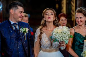 Wedding party members gather during an indoor celebration with decorative lighting and formal attire.
