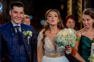Playful wedding party moment captured in elegant church setting with ornate details.
