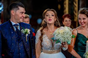 Celebratory moment captured during wedding ceremony in ornate church interior.
