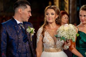 Wedding couple shares intimate moment during ceremony in ornate church setting.