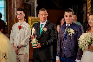 Wedding party members in formal attire gather during evening reception celebrations.