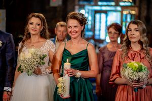 Wedding party members in formal attire pose during an evening celebration.