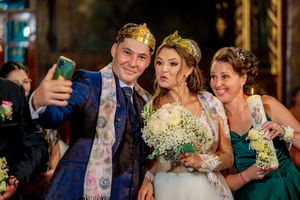 Wedding celebration selfie moment with attendants in emerald gowns.