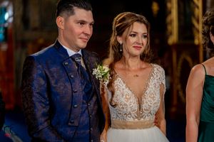 Wedding celebration with guests in formal attire under ornate chandeliers.