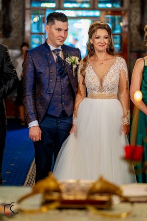 Wedding celebration captured in an ornate venue with golden decor and blue carpeting.