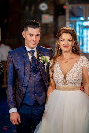 Formal wedding party members stand together in an elegant venue with decorative elements.