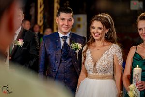 Wedding party members smile and celebrate in a beautifully decorated indoor venue.