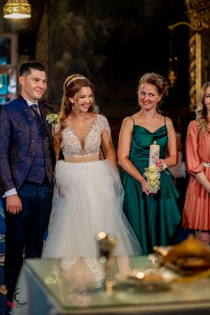 Elegant wedding reception scene with formal attire and decorative golden table settings.