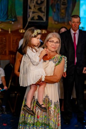 Wedding guests in floral dresses share an emotional moment during the celebration.