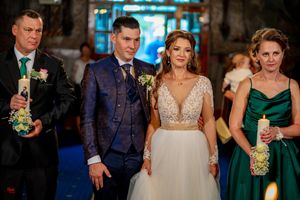 Wedding party members gather during an indoor ceremony with blue lighting accents.