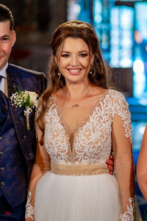 Close-up view of an ornate wedding gown featuring delicate lace appliques and sheer illusion neckline details.