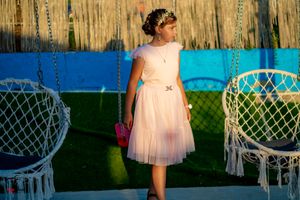 Elegant garden party setting with hanging macrame chairs and tulle decorations.