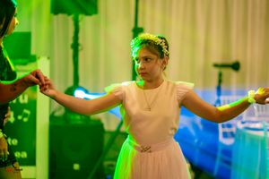 Dance performers moving dynamically under green theatrical lighting effects.