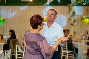 Couples dancing at a formal event with elegant decor and mood lighting.