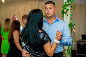 Social dancers moving across a decorated indoor venue with ambient lighting effects.