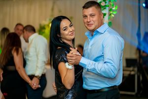 Dancers in formal attire performing ballroom dance moves at an evening celebration.