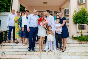 A group poses on the steps of a building entrance during a celebration.