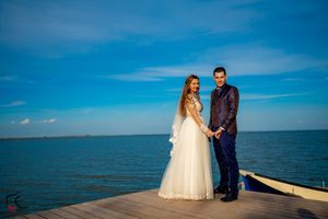 Romantic wedding portraits captured on a coastal dock during a sunny afternoon.
