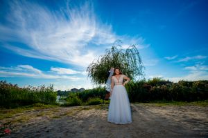 Scenic outdoor wedding location captured in wide angle with lush greenery and blue skies.
