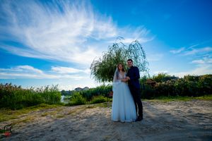 Panoramic view of a scenic outdoor wedding ceremony location with blue skies and natural landscape.
