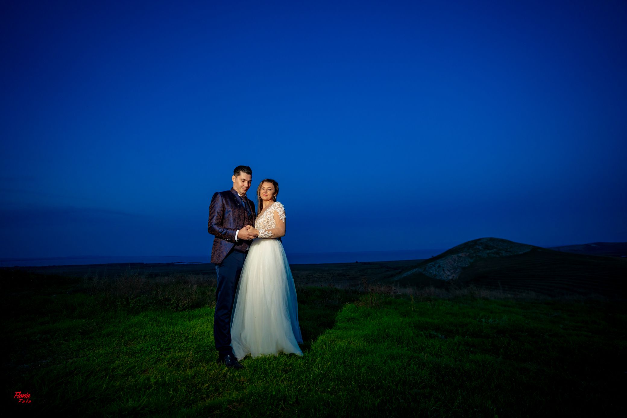 Twilight wedding photography with couple standing in natural landscape.