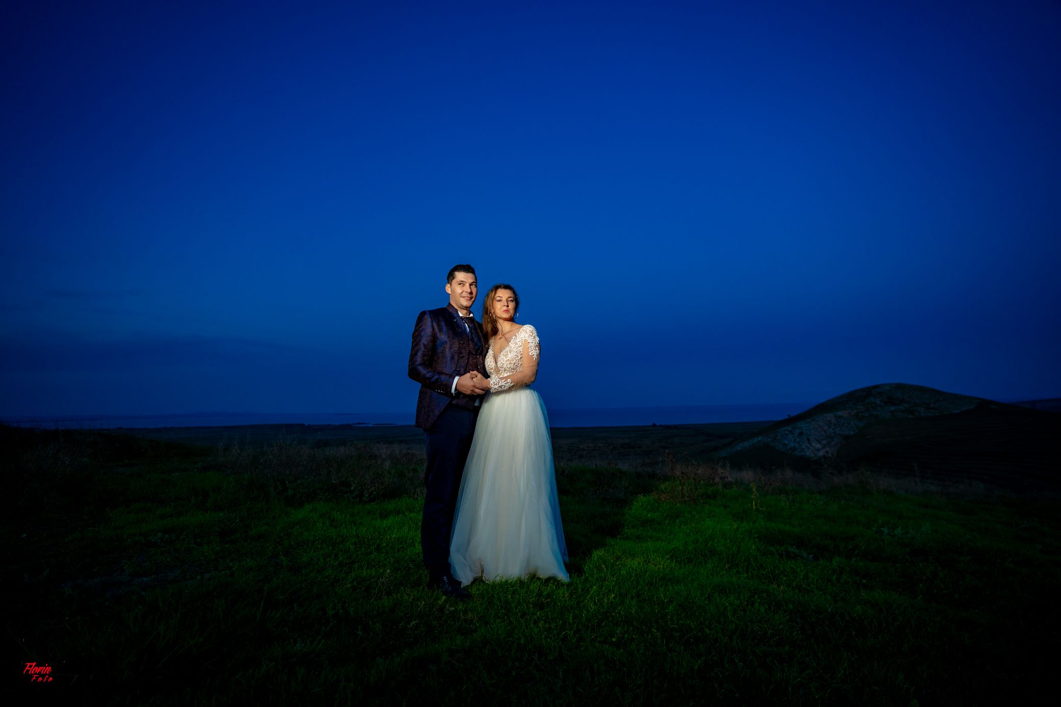 Evening wedding portraits with dramatic lighting and mountainous backdrop.