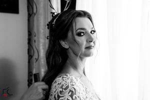 Dramatic black and white portrait of a bride in an elaborately detailed wedding gown.