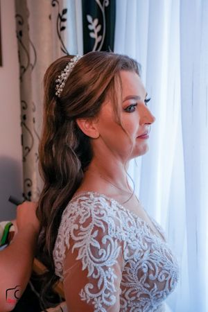 Artistic side view of a bride in a detailed lace wedding gown with sheer elements.