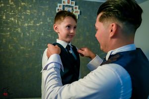 Two people in dress clothes having an animated conversation against a dark wall.