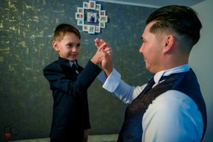 A celebratory hand gesture shared during a formal occasion preparation.
