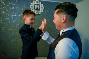 A playful high-five moment shared during formal event preparations.